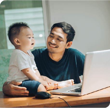 A father and his young son smiling and playing together on a laptop. A father and his young son smiling and playing together on a laptop.