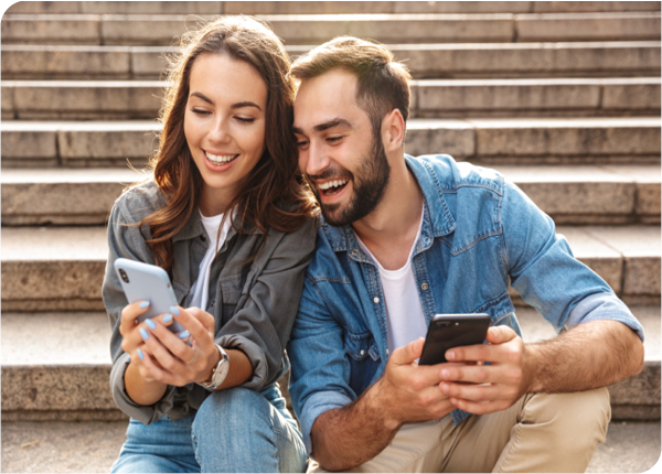 Smiling couple on their phones Smiling couple on their phones