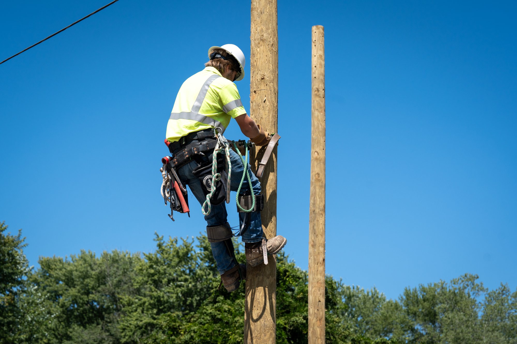 Fiber Internet installer climbing a pole Fiber Internet installer climbing a pole