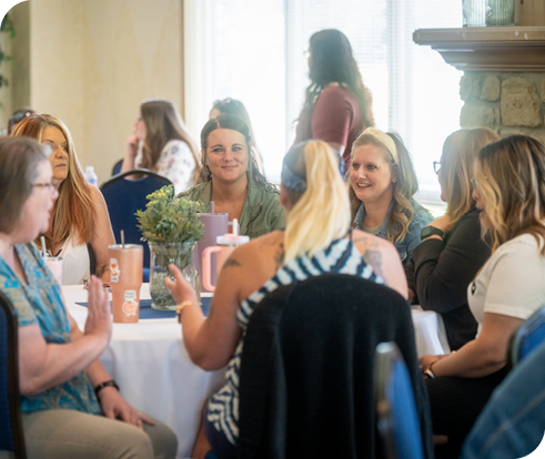 A table of Mainstream Fiber employees smiling and talking to one another.